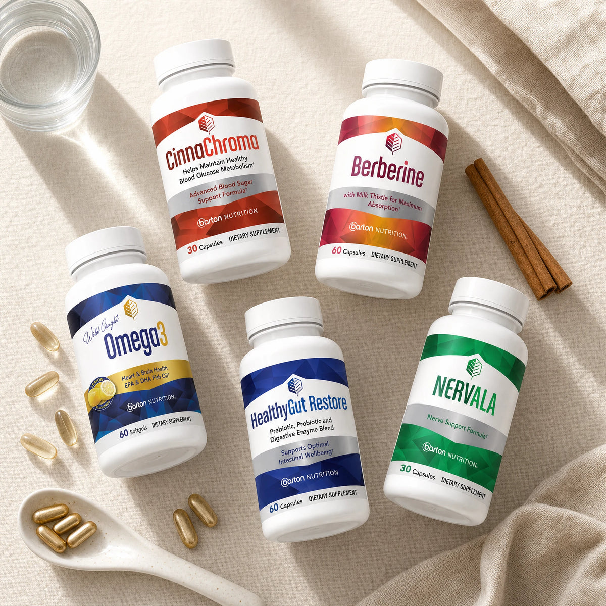 Flat lay of the five Metabolic Vitality Bundle bottles with capsules, softgels, cinnamon sticks, and a glass of water